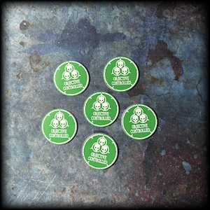 Peut inclure: Sept jetons de jeu circulaires verts avec du texte blanc et des graphiques de crânes. Chaque jeton indique "OBJECTIVE CONTROLLED" et comporte trois crânes dans un emblème blanc. Les jetons sont disposés sur une surface texturée bleu foncé et grise.