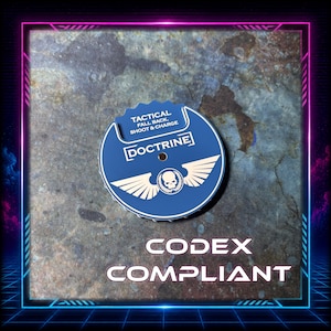 May include: A circular blue game token featuring a white skull emblem with wings, the text DOCTRINE, and the words TACTICAL FALL BACK, SHOOT & CHARGE. The token has a notched edge and a small central hole, presented against a textured grey background.