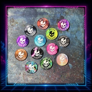 May include: A collection of twelve circular tokens featuring a white skull graphic with a lightning bolt crack and the text BATTLE SHOCKED. The tokens display various colours and finishes, including black, red, purple, blue, yellow, pink, and metallic.