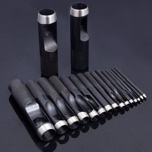 May include: A set of 17 black metal hole punch tools of varying sizes. The tools are arranged in a row, with the largest tool at the left and the smallest tool at the right. The tools are used for punching holes in leather, fabric, and other materials.