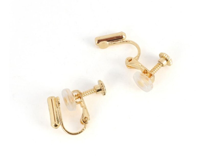 May include: Two gold-tone clip-on earring backs. Each back has a screw-on post and a clear plastic pad.