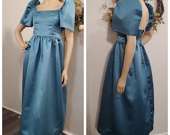 May include: A teal blue satin dress with puffed sleeves and a square neckline. The dress has a fitted bodice and a full skirt. The dress is shown from the front and back.