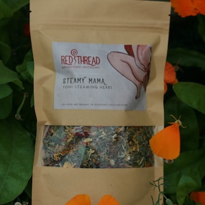 May include: A brown paper pouch with a label that says "Red Thread Bathing/Styling Apothecary" and "Steamy Mama Yoni Steaming Herbs". The pouch contains a blend of dried herbs.