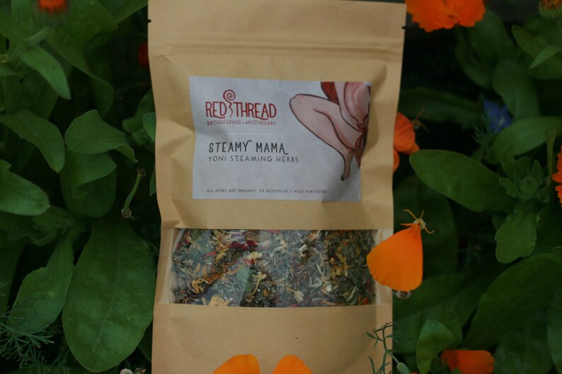 May include: A brown paper pouch with a label that says "Red Thread Bathing/Styling Apothecary" and "Steamy Mama Yoni Steaming Herbs". The pouch contains a blend of dried herbs.