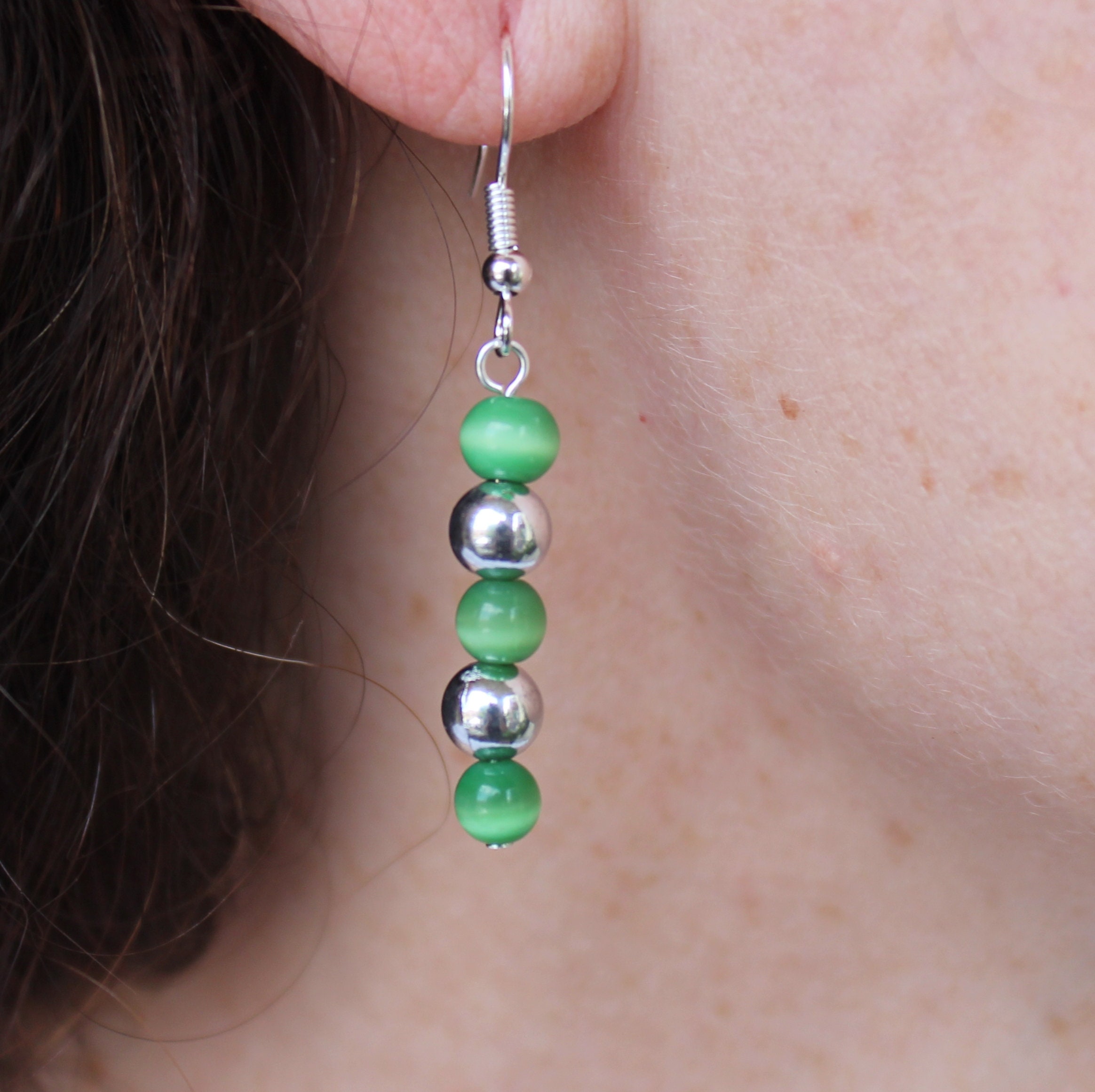 Green cat's eye glass beads and silvertone balls on Etsy