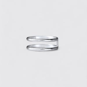 K&ouml;nnte beinhalten: Ein silberfarbener Ring mit einem Doppelband-Design. Die zwei d&uuml;nnen, glatten, kreisf&ouml;rmigen B&auml;nder sind an einer Seite durch einen einzelnen vertikalen Steg verbunden, was eine offene, parallele Struktur mit polierter, gl&auml;nzender Oberfl&auml;che ergibt.
