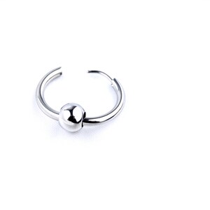 May include: A pair of silver-toned hoop earrings, each featuring a single polished, spherical bead threaded onto the circular wire band. The earrings have a smooth, reflective metallic finish and a simple, open-ended design for easy wear.