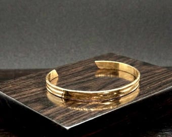 Unisex-Manschettenarmband aus 18-karätig vergoldetem Stahl · Minimalistisches, starres Goldarmband · Moderner Luxusschmuck · Elegantes Unisex-Accessoire.