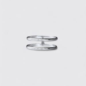 K&ouml;nnte beinhalten: Ein silberfarbener Ring mit zwei parallelen B&auml;ndern, die durch einen vertikalen Steg in der Mitte verbunden sind. Das Metall hat eine glatte, polierte Oberfl&auml;che mit einem reflektierenden Glanz, was eine schlichte Struktur f&uuml;r diesen Ring ergibt.