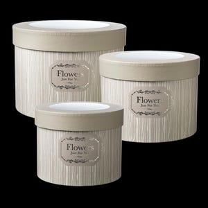 May include: Three round flower boxes in varying sizes. The boxes have a light beige, wood-grain pattern with matching lids. Each box features a label with the words "Flowers Just For You" in an ornate font.
