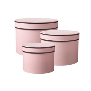 May include: Three pink, round gift boxes of different sizes. Each box features a black band around the top and bottom. The boxes are grouped together, with the smallest box at the front.