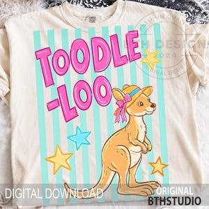 Può includere: T-shirt color crema con la scritta rosa "TOODLE LOO" su uno sfondo a righe verticali azzurre. È raffigurato un canguro dei cartoni animati con un cappello con un fiocco rosa. Stelle gialle e blu sono sparse intorno al canguro. "DOWNLOAD DIGITALE" e "ORIGINAL BTHSTUDIO" sono stampati in basso.