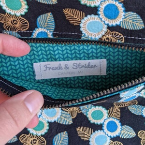May include: A black zippered pouch with a green and white patterned lining. The pouch has a label that reads "Franke & Striden, Canton MI".