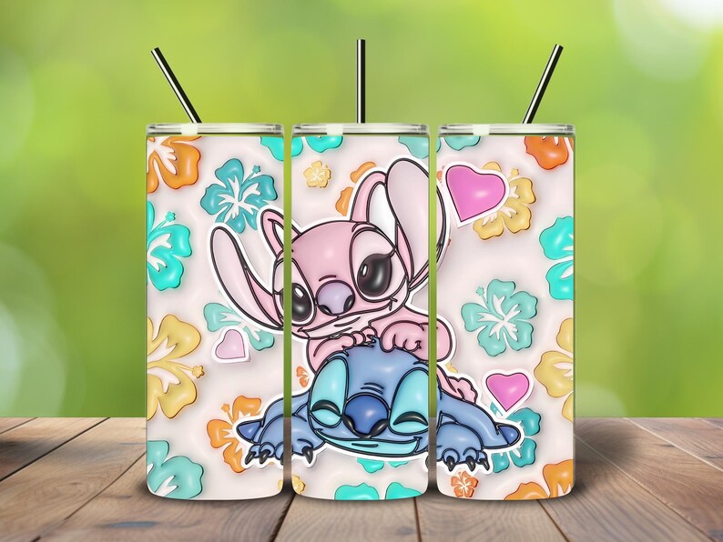 May include: A set of three stainless steel tumblers with black straws. Each tumbler features a cartoon illustration of Stitch and Angel, surrounded by colorful flowers and hearts. The background is a light cream color.