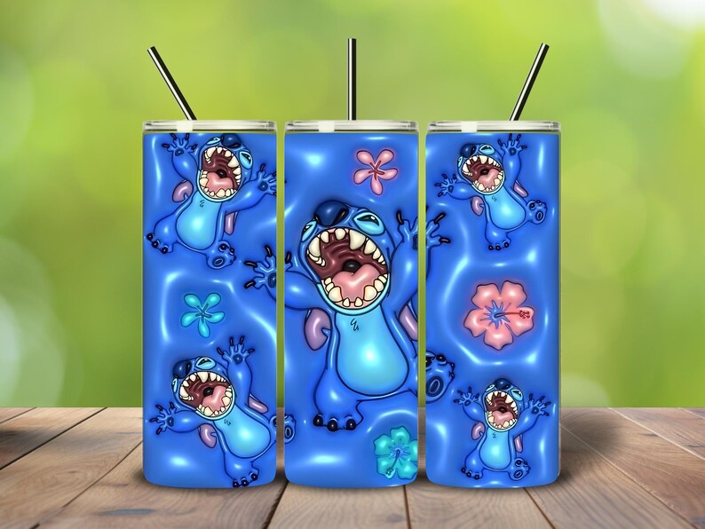 May include: Three blue insulated tumblers with a cartoon character design. The design features a blue alien with an open mouth, surrounded by flowers. Each tumbler has a black straw.