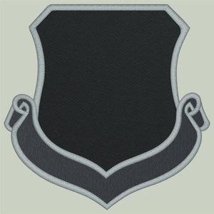 May include: A black embroidered patch with a gray border in the shape of a shield with a scroll at the bottom.