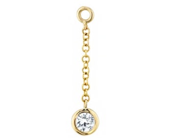 May include: A gold chain earring with a small, clear diamond at the end.