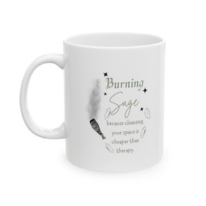 May include: White ceramic mug with a black and white illustration of a smoldering sage bundle and the text "Burning Sage because cleansing your space is cheaper than therapy."