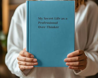 Puede incluir: Un libro de tapa dura azul con el título "My Secret Life as a Professional Over-Thinker" en la portada.
