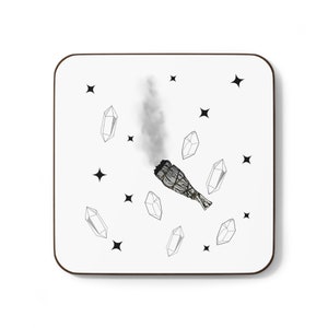 May include: White coaster with a black and white illustration of a smoldering sage bundle and crystals. The background is white with black stars.
