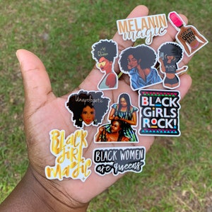 May include: A collection of colorful stickers with empowering messages and illustrations. The stickers feature phrases like "Melanin Magic," "Black Girls Rock," and "Black Women are Queens." The designs include portraits of Black women and various graphic elements.