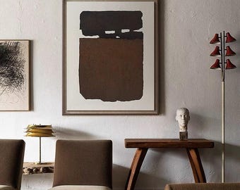 May include: A brown abstract painting in a wooden frame hangs on a white wall above a wooden console table with two brown chairs. A brass lamp sits on the table. A white plaster bust sits on the table. A white floor lamp with red shades is in the background.