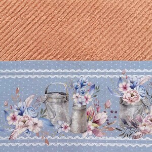 Puede incluir: Un pa&ntilde;o de cocina azul y blanco con un borde de encaje blanco. El patr&oacute;n presenta tres regaderas vintage con ramos de flores.