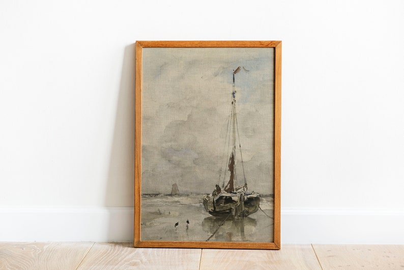 May include: A framed watercolor painting of a sailboat on a beach with a cloudy sky. The sailboat has a brown hull and a white sail. There are three small birds in the foreground.