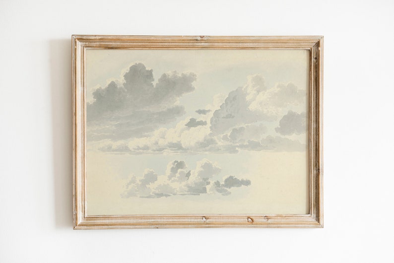 May include: A framed watercolor painting of a cloudy sky. The clouds are painted in shades of gray and white, and the background is a light blue.