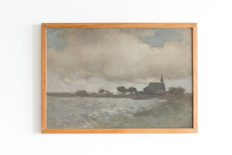 May include: A framed painting depicting a landscape with a church in the distance. The sky is cloudy and gray, and the water in the foreground is choppy. The painting is in a wooden frame.