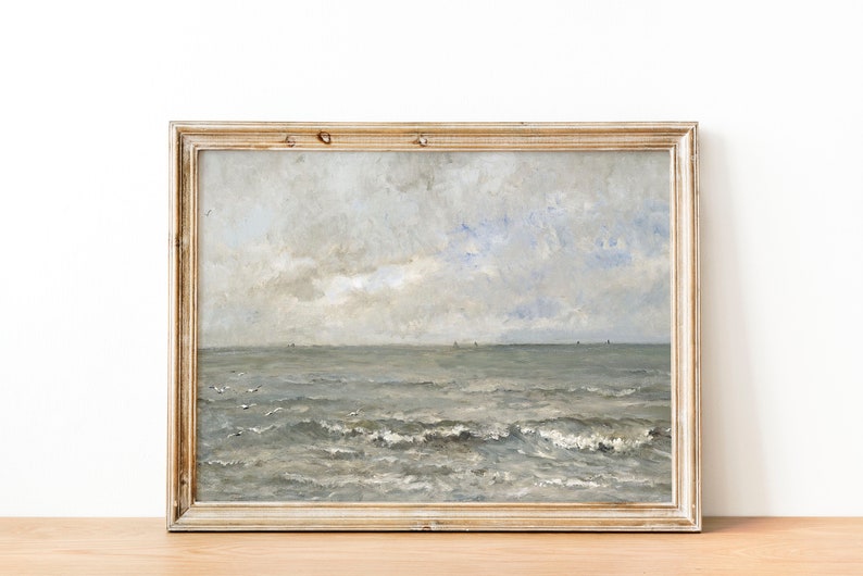 May include: A framed painting of a seascape with a cloudy sky and choppy waves. The painting is in a light wood frame.