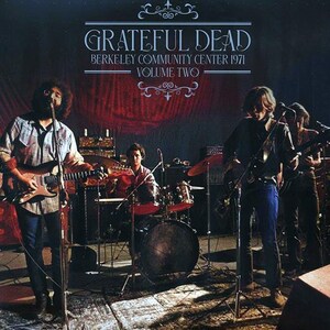 May include: A black and white photo of a band performing on stage. The band is called "Grateful Dead" and the concert took place at the Berkeley Community Center in 1971. The photo is titled "Volume Two".