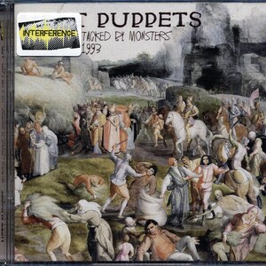 May include: A CD case with a colorful painting of a medieval scene. The title of the album is "Attacked by Monsters" by the band "Puppet" and the year 1993 is printed below the title.