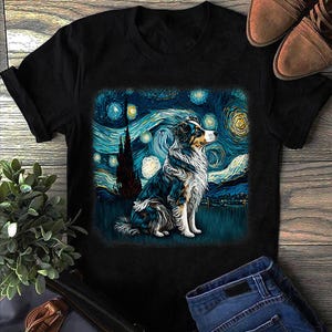 May include: Black t-shirt with a dog design in the style of Van Gogh's "Starry Night." The dog has blue, black, and white fur, set against a swirling night sky. The shirt is shown with blue jeans and brown shoes.
