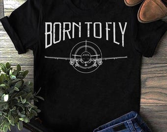 Puede incluir: Camiseta negra con texto blanco que dice "Born to Fly" y un contorno blanco de un avión.