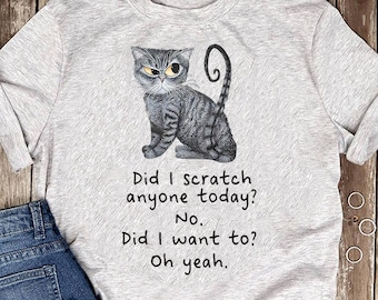 May include: A gray t-shirt with a cartoon cat illustration and the text "Did I scratch anyone today? No. Did I want to? Oh yeah."