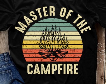 May include: A black t-shirt with a vintage-style graphic of a campfire with the text "Master of the Campfire" in white.