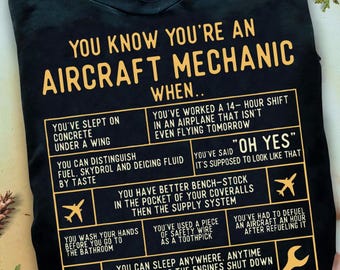 May include: Black t-shirt with a yellow graphic that says "You know you're an aircraft mechanic when..." and lists several humorous situations that only an aircraft mechanic would understand.