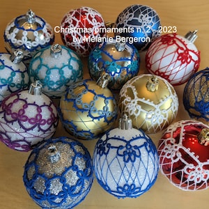 Peut inclure: Une collection de 12 boules de Noël faites à la main, chacune présentant des motifs crochetés complexes dans différentes couleurs, notamment le blanc, le rouge, le bleu, l'or, l'argent et le violet. Les boules sont décorées de motifs de dentelle délicats et sont prêtes à ajouter une touche de charme artisanal à votre décoration de Noël.