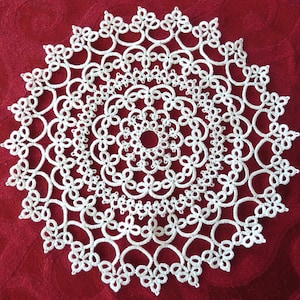 Peut inclure: Une dentelle crochetée blanche avec un motif circulaire présentant des motifs complexes et plusieurs couches.