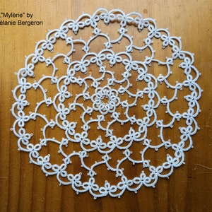 May include: White crocheted doily with a spiral pattern. "Mylène" by Mélanie Bergeron.