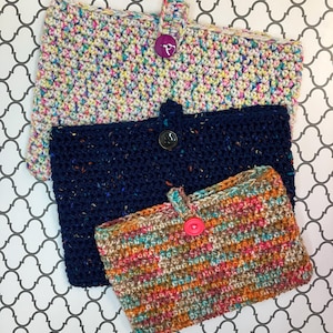May include: Three crocheted pouches with different colored patterns and button closures. The top pouch is white with multi-colored flecks, the middle pouch is navy blue with black flecks, and the bottom pouch is a mix of brown, orange, and teal.