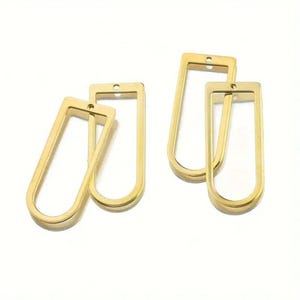 May include: Four gold-toned metal jewelry components, each shaped as an elongated U-frame with a flat top bar and a small circular hole for attachment. These open-center rectangular charms feature rounded bottom corners and a smooth, polished finish.