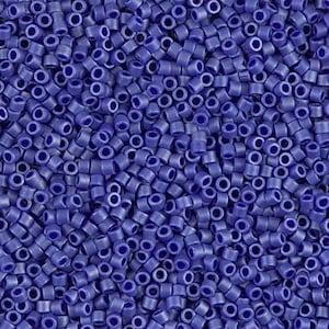 May include: A close-up image of a large quantity of small, round, opaque blue beads. The beads are all the same size and shape, and they are arranged in a random pattern.