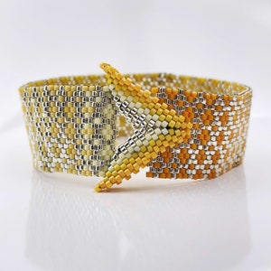 Może przedstawiać: Bransoletka z żółtych i srebrnych koralików z geometrycznym wzorem. Bransoletka ma unikalne zapięcie w kształcie gwiazdy.