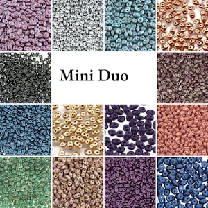 Könnte beinhalten: Eine Sammlung von Mini Duo-Perlen, dargestellt in einem Raster aus zwölf verschiedenen Farbvariationen, einschließlich metallischer, matter und glänzender Oberflächen. Jeder Abschnitt zeigt kleine, ovale Perlen mit zwei Löchern in Violett, Silber, Türkis, Bronze, Schwarz und Blau.