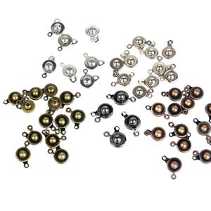May include: Assortment of metal clasps with a ball in the center. The clasps are available in three colors: silver, gold, and bronze.