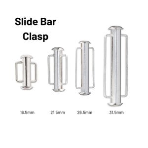 Op de afbeelding: Vier zilverkleurige metalen schuifsluitingen gerangschikt in oplopende grootte. De tekst Slide Bar Clasp staat boven de items, met de labels 16,5 mm, 21,5 mm, 26,5 mm en 31,5 mm onder elk bijbehorend metalen sieraadonderdeel geplaatst.
