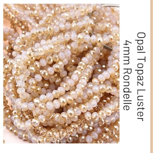 May include: A collection of faceted rondelle beads in opal topaz lustre, each measuring 4mm in diameter. The beads are strung together in multiple strands, displaying a translucent, light-reflecting golden and pale beige colour palette throughout.