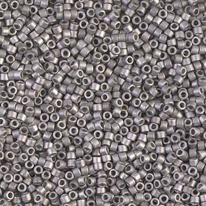 May include: A close-up view of a large quantity of small, round, silver-colored beads. The beads are all the same size and shape, and they are arranged in a random pattern.